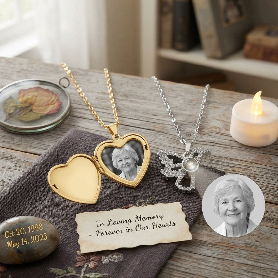 A memorial photo locket necklace and a photo projection necklace displayed on a wooden table alongside a lit candle, a dried flower, a commemorative stone, and a memorial note.