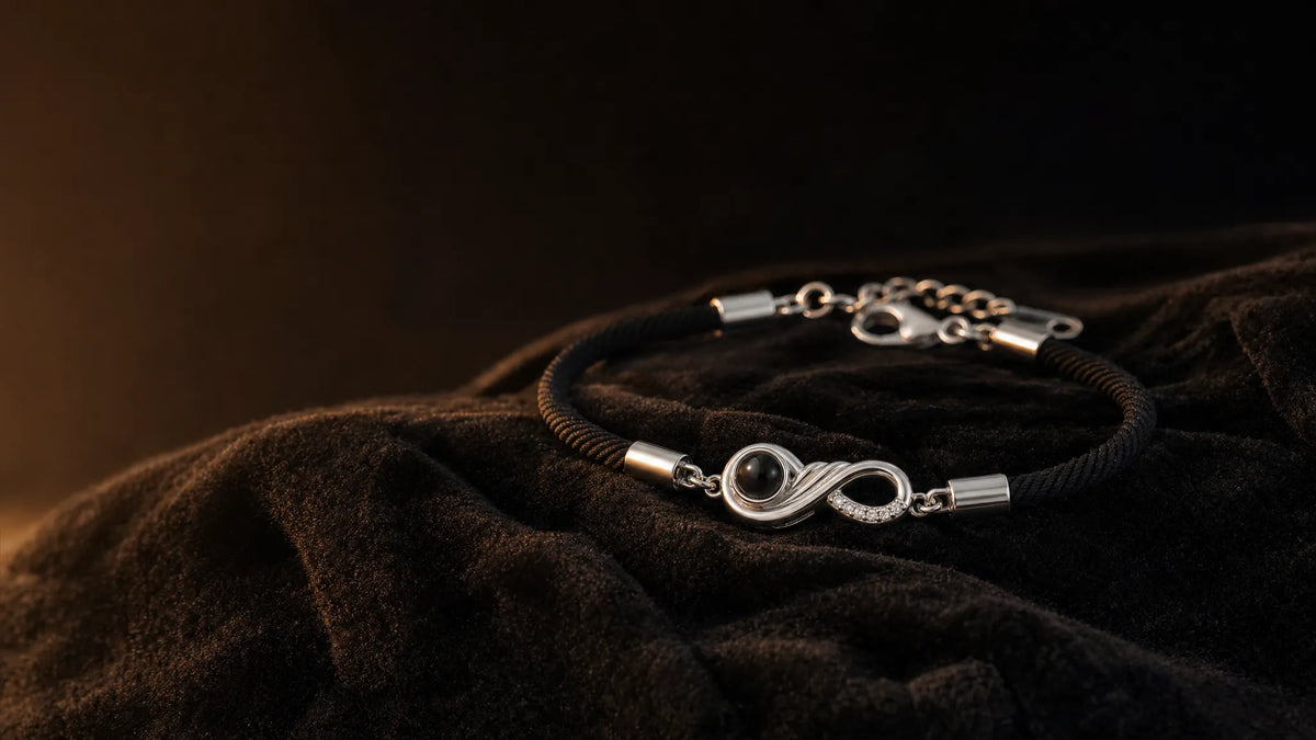 A photo projection bracelet resting on dark velvet in warm light, its dark round lens disc in focus at the front