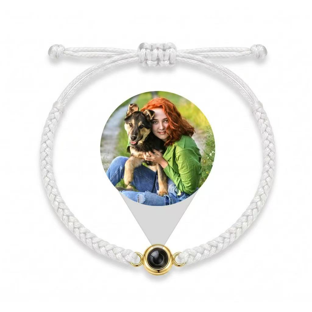 A white braided photo projection bracelet with a pet photo revealed through its gold optical stone